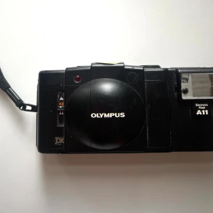 Olympus XA3 Analog Kamera - Olympus XA3 kamera medföljande blixt-tillbehör. Mycket ovanlig modell olympus XA3 serien, kompakt analog kamera. Bra skick, sällan använd. Köpt för 2299kr, säljer för 950kr