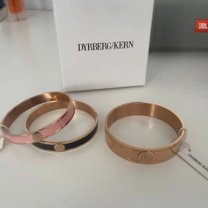 Armband  - Säljer dessa tre armband då dom aldrig har kommit till användning💕 De svarta och rosa armbanden är nypris 699kr så jag säljer dom för 400kr Den stora guldiga armbandet är nypris 799kr och säljer den för 500kr