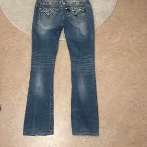 Miss me jeans - Det är bootcut jeans och är aldrig använde säljer pågrund av att de är för stora och köpta här på Plick. Passar på längden för mig som är 176. Innerbenslängden är 81 cm, måttet runt midjan är 86cm 