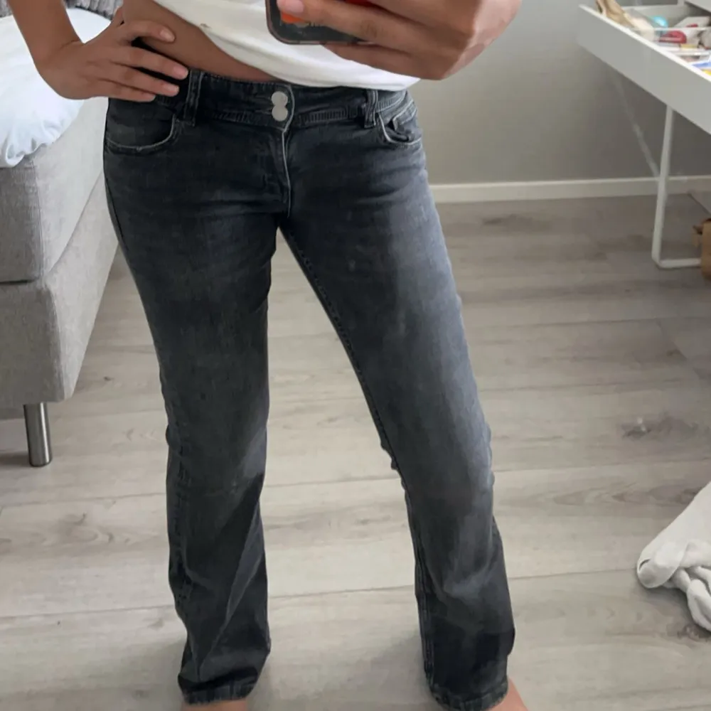 Ett par grå jeansbyxor i storlek S. Byxorna har en knapp och dragkedja framtill samt fickor både fram och bak. De har en normal passform och är raka i modellen.. Jeans & Byxor.