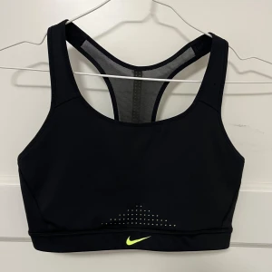 Nike Sport-bh - Superfin och nästan helt oanvänd sportbh från Nike i storlek M. Endast använts två gånger. Lite tjockare material på framsidan och lite mesh-aktigt håligt på bakaidan vilket gör ryggen luftig och skön. Är något stor för mig och därför används den ej.