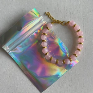 egen gjort armband  - rosa design med guld detaljer, 25kr