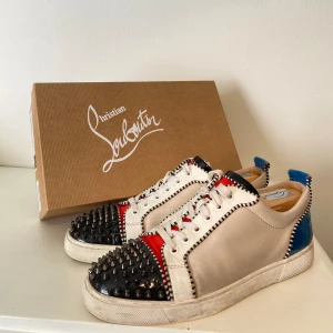Christian Louboutin multicolor Leather  - Hej, säljer ett par enormt snygga Christian Louboutin sneakers. Unika & sällsynta, utstickande & exklusiva. Välanvända, saknar ett antal spikar. Nypris över 8k. Storlek 43. Lätta att hålla rent. Bekväma att gå i. Pris kan diskuteras. Hörs i DM! 