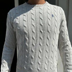 Ralph Lauren Kabelstickad övertröja - Ljusgrå - Kabelstickad Ralph Lauren tröja i mycket bra skick, storlek M. Säljer pga vuxit ur den. Passar dig som är 175-185