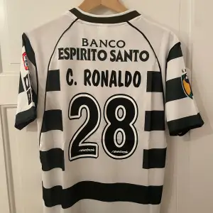 Säljer en Cristiano Ronaldo fotbollströja i Sporting från hans genombrottssäsong där han bar nummer 28. Helt ny med tagg. Tröjan är en reprint. Storlek: M. Ansvarar ej för postens slarv. Endast handtvätt. Gnugga ej på blöta prints.