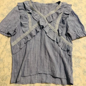 Ljusblå Volangblus - Jättefin kortärmad volangblus ⭐️Köpt tidigt i år så den är fortfarande väldigt ny och i bra skick💕Sitter väldigt fint på. Köpte den i en mall i Thailand, kommer tyvärr inte ihåg vilken butik den är ifrån.