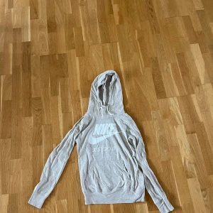 Tunn nike hoodie - Nike hoodie med tunnt material. Snörning vid luvan. Hoodien är i bra skick och har använts fåtal gånger. Väldigt skrynklig på bilden men inte alls lika skrynklig i verkligheten. (Går såklart att stryka) 
