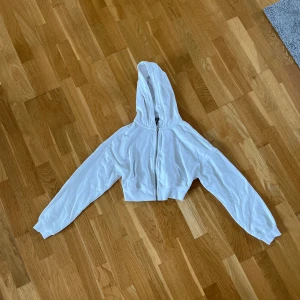 Magtröje hoodie - Hoodie/munkjacka med dragkedja som är kortare och påminner om en magtröja. Hyfsat oanvänd därav fortfarande bra skick.