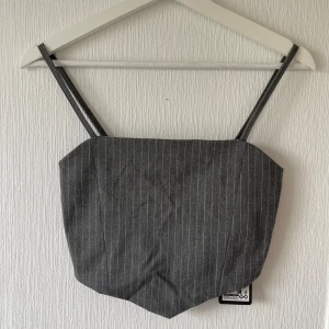 Grå topp - Snygg men simpel topp som är oanvänd då storleken är för liten för mig. Passar bra till mycket. Justerbara axelband. Väldigt lite stretch. 