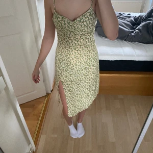 Söt blommig sommarklänning  - Medellång blommig klänning. Jättefin en sommardag! Har en slit på ena benet!