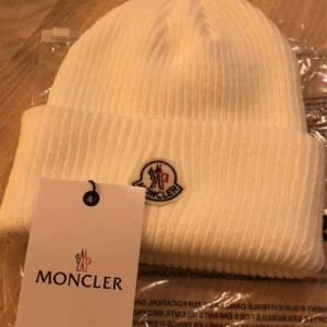 Moncler mössa - Säljer min moncler mössa då den inte används längre. Jätte fint skick, bara pyttelite beige på insidan av smink men det syns knappt och det syns inte när man har på sig den. Osäker på äkthet därav priset💗