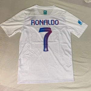 Ronaldo Al nassr Jersey 23/24 - Cristiano Ronaldo Al nassr tröja från säsongen 23/24. Säljer pga av att jag inte är ett fan av Ronaldo. Tröjan är storlek S och är helt ny och helt oanvänd. 