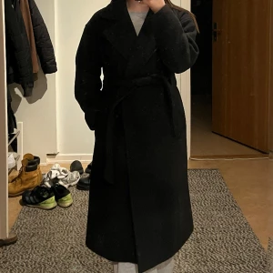 Svart kappa  - Svart kappa från Vero Moda, är 160cm lång. Ok skick, söndrig insidan (bild 3). Nypris 779kr 