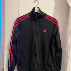svart-rosa ADIDAS track jacket!! 💗🖤 - säljer en svart adidas track jacket med rosa streck! superskön och bekväm hehe 💞 obs! barnstorlek, men passar mig i XS/S! ✨ SKA FLYTTA UTOMLANDS SÅ ALLT MÅSTE BORT INNAN 17 MARS ✨ annars slängs det på tippen 🥲 