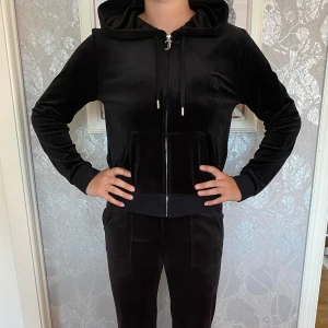 Juicy Couture - Juicy Couture set  I färgen Svart Material: Velour Överdel i stl: L (mindre i stl) Nederdel i stl: S Fint skick, se bilder.  Pris tröja: 700:- Pris byxor: 700:-  Vid köp av tröja/byxor paketpris 1200:- 