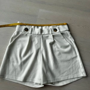 Vita shorts - Använd ett fåtal gånger, normal i storlek. Väldigt bekväma, men är lite seethru. Fina midjedetaljer. Lapp med materialinformation avklippt, men känns som bland annan polyester.