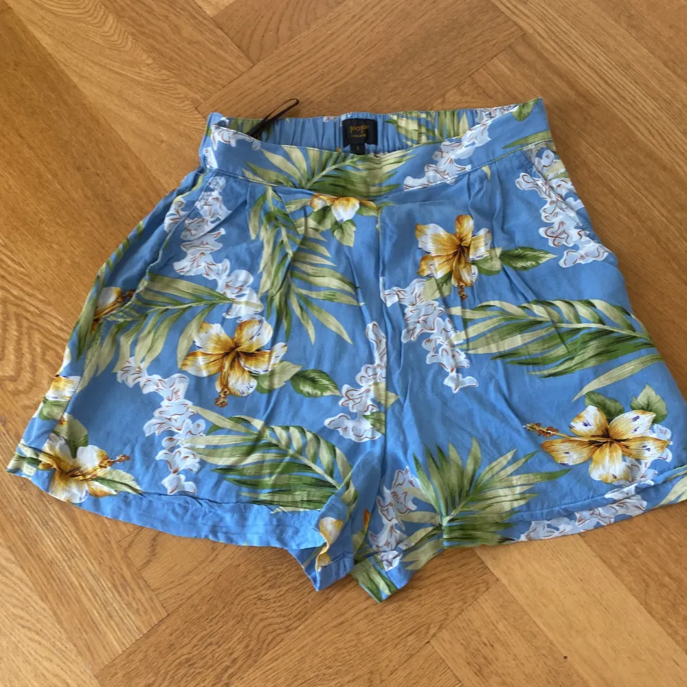 Blommiga shorts från pop boutique i Göteborg, storlek ”1”, vilket jag gissar är runt XS. Blixtlås på sidan. Shorts.