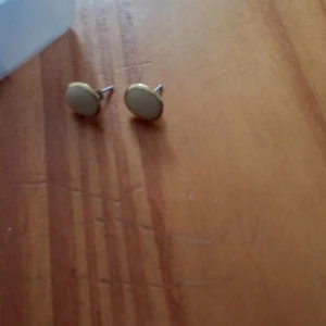 Små örhängen guldfärgad metall med vit gula sten - Små örhängen med vit gula sten stift.