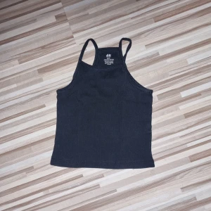 Svart linne från H&M - Ett svart linne från H&M med smala axelband. Linnet har en enkel design som passar till många olika tillfällen. Storlek 134/140