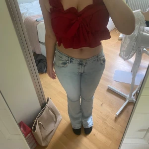 Topp - Jag säljer en jätte fin röd topp. Köpt i Thailand så står ingen storlek men skulle gissa på L. Är resår på bak sidan så kan töjas. Säljer den då den är förlåten i bysten. Använd en gång endas några timmar. 