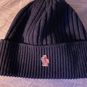 Moncler mössa - Säljer nu min Moncler mössa då jag inte använder den, den är köpt på Monclers hemsida. Kvitto finns!