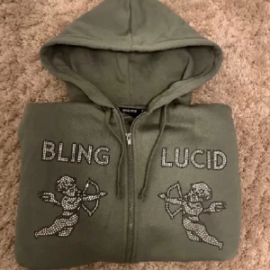 Bling lucid rhinestone zip hoodie - Skit snygg Bling lucid rhinestone zip hoodie i storlek M i väldigt bra skick använd i runt 1 månad. Färg: oliv grön