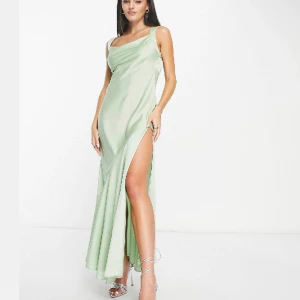 Balklänning grön satin - Helt ny jättefin balklänning med lapp kvar och i originalförpackning. Beskrivs som salviagrön, unik design med fin knytning i ryggen. Köpt för 1069kr, säljs för 800kr