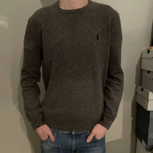 Ralph Lauren tröja - En riktigt fräsch grå ralph lauren tröja i 100% merino ull! Storlek M men kan passa S om man har lite bredare kroppsform. 10/10 skick. Nypris kan gå mellan 1600-2200 kr. Vårt pris 449 kr! Modellen är cirka 180 och väger runt 60 kg. 