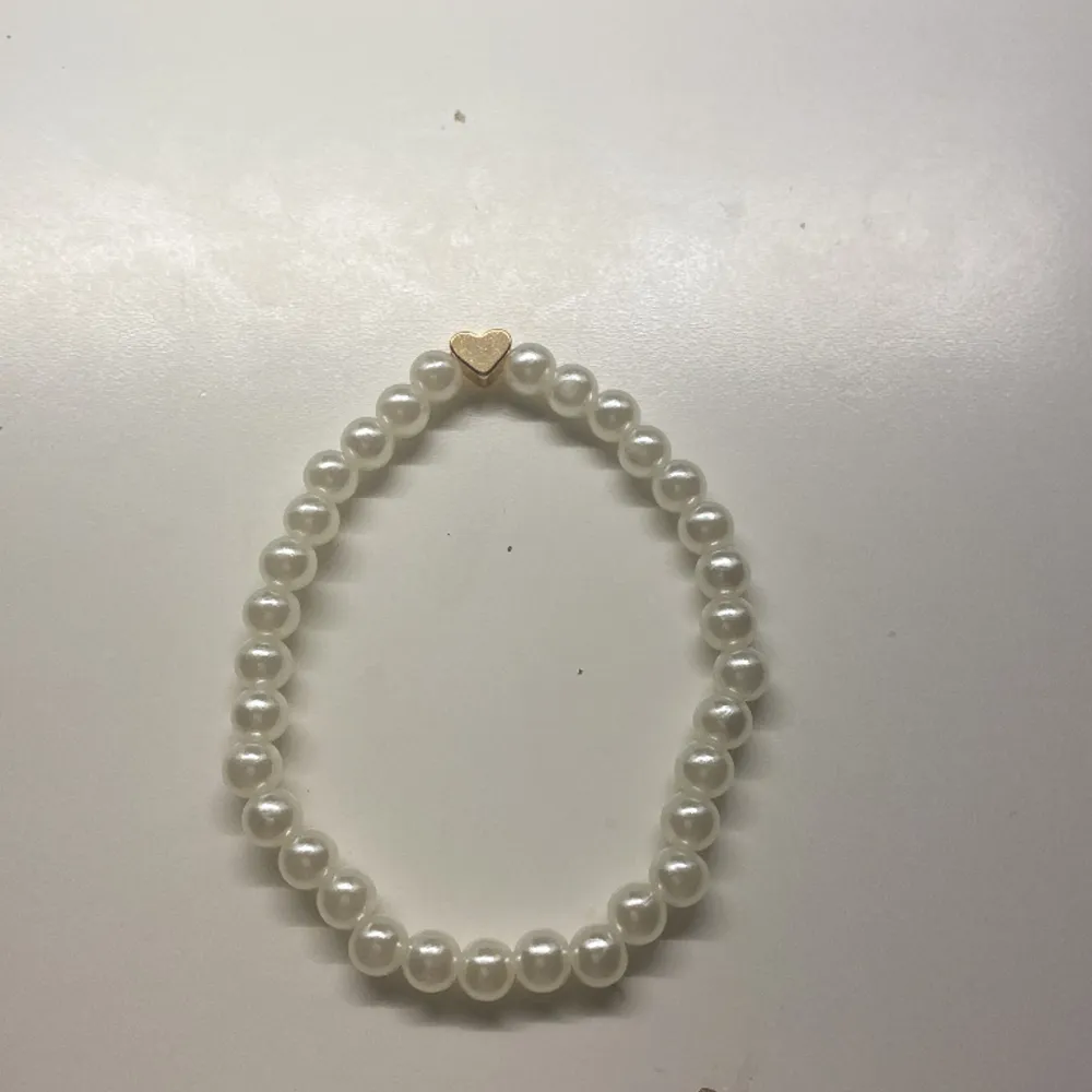 Det är en jätte fin armband med runda vita pärlor. Två för en.. Accessoarer.