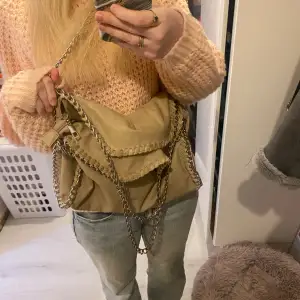 En så fin beige väska liknar stellaMccartney väskorna, den är i fint skick utöver lite färg som lossnat på ena kedjan men inget som syns vid användning, sen liten skada i tyget men går att laga och har inte stört mig vid användning💓 skriv för frågor 