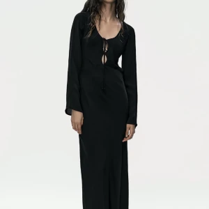 Svart maxiklänning från zara strl S - Fin långärmad maxiklänning från zara med öppen rygg! Fin knytning vid brösten. Nypris 699, endast använd en gång. Frakt tillkommer