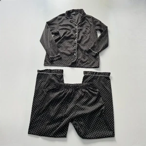 Prickig pyjamas - Prickig pyjamasset från Secret Possessions i siden / silkes liknande material. Byxor midjemått: 68-106 cm (resårband och snöre). Innerbenslängd: 77 cm 💖