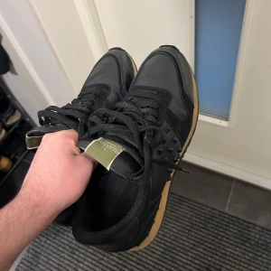 Valentino skor - Valentino rockrunners i sjukt snygg modell, diskret färg med spikar vilket jag diggar men tyvärr ej använder. Skorna är storlek 43 och passar mig som bär storlek 42 vanligtvis. Använt skick, dock mycket kvar att ge. ENDAST SKOR.