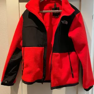 Snygg röd North Face jacka i nyskick endast använt en gång. Köpt länge sen men bara stannat i garderoben.  Inga defekter alls, vid fler frågor kom DM👍