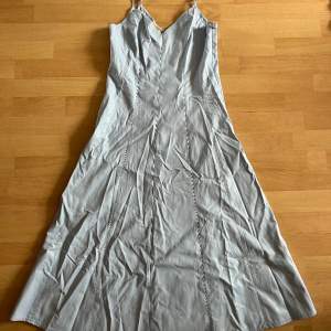 Ljusblå klänning i strlk 38 (stor i storleken). Läder-aktigt material. Aldrig använd, lappar kvar.
