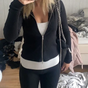 Weekday Zip Up Tröja  - Säljer denna as snygga figursydda zip up tröjan med luva från Weekday som nu är slutsåld i svart! Den är i toppskick (inga defekter) och nypriset är 470 kr + frakt
