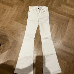 Flare jeans - vit/beige BERSHKA  - Jätte fina flare jeans från BERSHKA har använt dom 1 gång och tycker inte dom passar mig så mycket! Jätte fina jeans och materialet är jätte bra! Storleken är 34 men passar även 32!