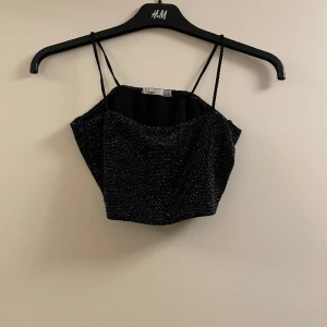 Glittrig kort topp - Säljer min snygga glittriga korta topp från Nelly som inte passar mig längre. Använd den fåtal gånger, fortfarande bra skick som ny! 