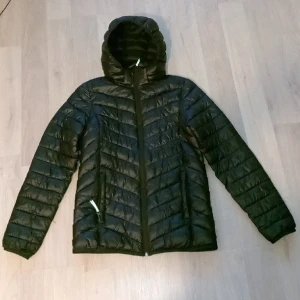 Glansig Pufferjacka Mckinley - En cool glansig svart pufferjacka från McKinley som är storlek 158-164 och är ett billigare alternativ till Moncler. Köpt för 599kr. Pris kan diskuteras.