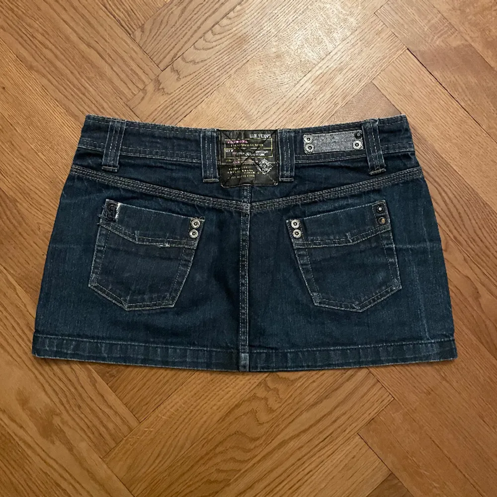 Lågmidjad minikjol denim! Köpt second hand, använd 2-3 gånger av mig! Storlek 38 Saknas en svart sten på höger bakficka (bild 3), men är utöver det i bra skick!  Midjemått rakt över: 42 cm Längd totalt: 32 cm. Kjolar.