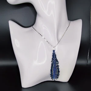 Handgjort halsband  - Min mamma tillverkar och designar egna smycken. Detta halsband är gjort i små glaspärlor. Hänget är 6.5 cm och kedjan 44 cm och i äkta silver.