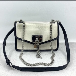 DKNY Women's Elissa Small Perforated Shoulder Bag in White/Black Size 5 - Framed black piping and accented with polished hardware, this unique shoulder bag is a perfect addition to your closet. The perforated finish and the adjustable strap offers a lightweight option that boasts endless styling opportunities; Logo plate at fro