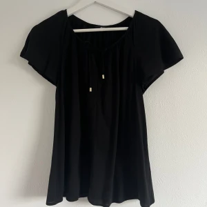Blus  - Fin svart blus med lite volangarm och knyte med gulddetaljer, från Ellos. Blusen är endast använd ett fåtal gånger och i väldigt fint skick.