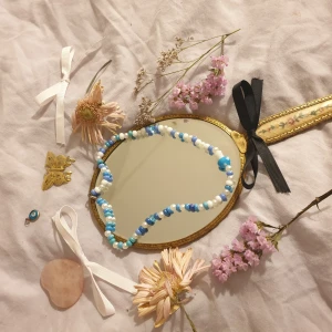 🎀handgjort halsband🎀 - Ett blått handgjort halsband med en flugsvamp i mitten.