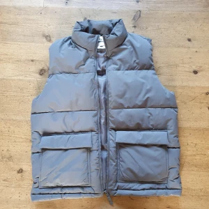 Väst - Helt ny väst. Aldrig använd. Liknar en canada goose väst. Grå storlek M och passar både orten stil och grish. Priset kan diskuteras lite