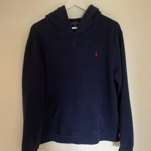 Polo Ralph Lauren hoodie - Polo Ralph Lauren hoodie i använt skick. Inga defekter förutom den är lite urtvättat. Står XL i den men passar mig som har M/L. Skick 7/10. Pris går att diskutera 