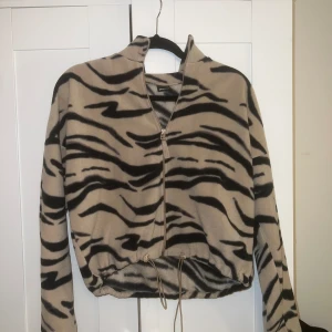 Fleecetröja - Mönstrad tröja med dragkedja.  Kan dras åt i midjan. Använd fåtal gånger.