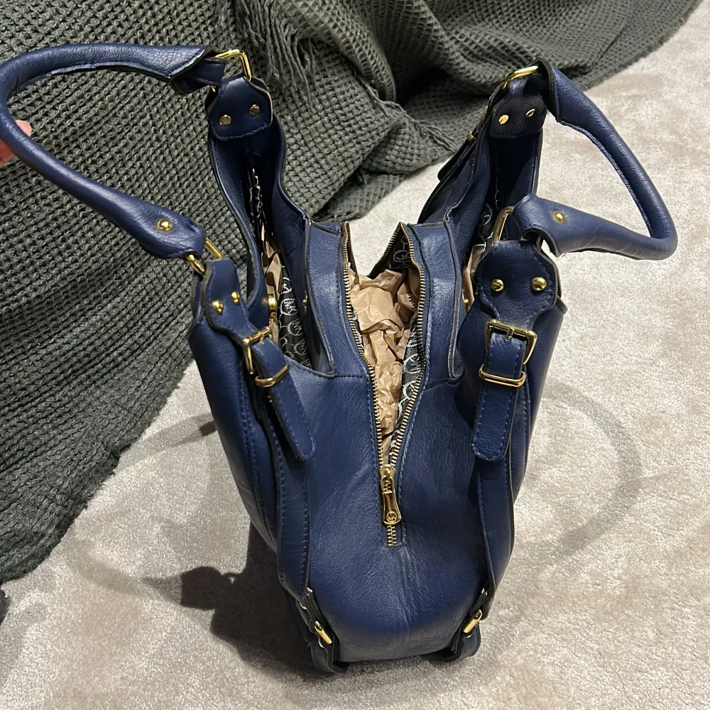 Michael Kors väska i mörkblå med 3 fack Använd men i bra skick Ca mått: H:50cm (inklusive handtag B: 37cm. Väskor.