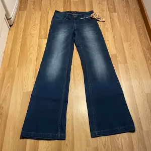 (8) lågmidjade bootcut jeans med massa stretch i, helt nya med lappar kvar. Midjemått rakt över: 33cm men passa mke större, innerbenslängd: 82 cm 🩵