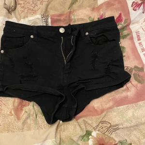 Svarta korta shorts - Svarta korta shorts med slitningar i fram, finns i fler färger